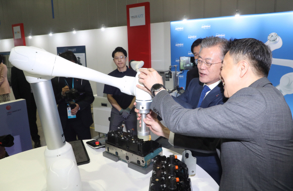 문재인 대통령이 22일 오전 ‘로봇산업육성 전략보고회’가 열린 대구 달성군 현대로보틱스에서 현장 관계자와 로봇을 이용한 작업을 시연하고 있다. 2019.3.22 도준석 기자 pado@seoul.co.kr