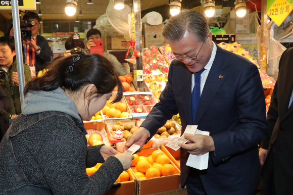 문재인 대통령이 22일 지방경제투어 일곱번째로 대구를 방문했다. 문 대통령이 칠성종합시장을 방문해 상인들의 애로사항을 경청한 뒤 시장을 둘러보며 과일과 봄나물 등을 구입하고 상인들과 인사를 나누고 기념촬영을 했다. 2019.3.22 도준석 기자 pado@seoul.co.kr