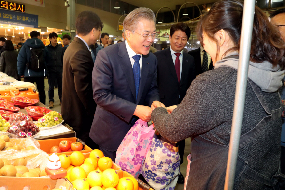 문재인 대통령이 22일 지방경제투어 일곱번째로 대구를 방문했다. 문 대통령이 칠성종합시장을 방문해 상인들의 애로사항을 경청한 뒤 시장을 둘러보며 과일과 봄나물 등을 구입하고 상인들과 인사를 나누고 기념촬영을 했다.  2019.3.22 도준석 기자 pado@seoul.co.kr