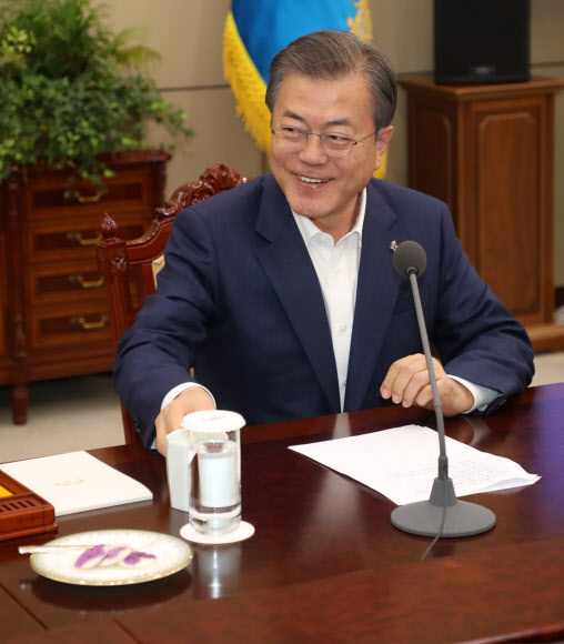 문재인 대통령이 25일 오후 청와대에서 수석보좌관회의 모두발언 후 대화하고 있다. 문 대통령 앞에 놓인 화전은 김정숙 여사가 회의 참석자들을 위해 인수문 진달래꽃으로 만들어 준비했다. 2019.3.25  연합뉴스