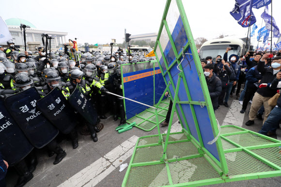27일 오후 서울 여의도 국회 앞 의사당대로에서 열린 ‘국제노동기구(ILO) 핵심협약 비준과 노동기본권 쟁취 민주노총 전국노동자대회’에서 경찰이 질서유지를 위해 설치한 펜스를 끌어당기며 시위 참석자들과 대치하고 있다. 2019.3.27  연합뉴스
