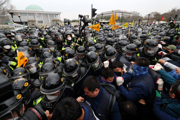 27일 오후 서울 여의도 국회 앞 의사당대로에서 열린 ‘국제노동기구(ILO) 핵심협약 비준과 노동기본권 쟁취 민주노총 전국노동자대회’에 참가한 참석자들이 경찰과 몸싸움을 벌이고 있다. 2019.3.27  연합뉴스