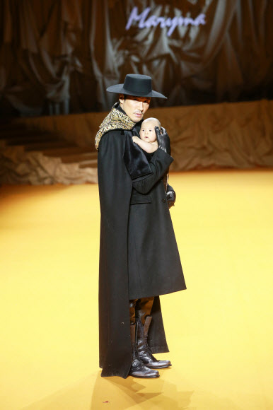 아기를 안은 중국 배우 후빙이 30일(현지시간) 중국 베이징에서 열린 ‘차이나 패션 위크’에서 마얀 리의 ‘마리아 컬렉션’의 작품을 선보이고 있다. AFP 연합뉴스