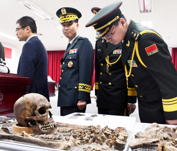 1일 오전 인천시 계양구 ‘중국군 유해 임시안치소’에서 열린 중국군 유해 10구에 대한 입관식에서 한국 유해발굴감식단과 중국 퇴역군인사무부 실무단이 입관식에 앞서 유해를 둘러보고 있다. 2014년 이후 여섯번째 송환하는 이번 중국군 유해는 지난해 3월부터 11월까지 DMZ내에서 발굴한 유해를 신원확인 과정을 거쳐 중국군으로 판정된 유해를 송환하는 것이다. 2019. 4. 1.  사진공동취재단