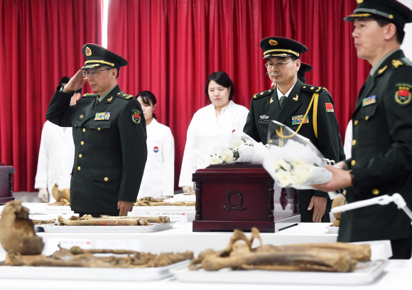 1일 오전 인천시 계양구 ‘중국군 유해 임시안치소’에서 열린 중국군 유해 10구에 대한 입관식에서  중국 퇴역군인사무부 실무단을 포함한  관계자들이 입관에 앞서 경례를 하고 있다. 2014년 이후 여섯번째 송환하는 이번 중국군 유해는 지난해 3월부터 11월까지 DMZ내에서 발굴한 유해를 신원확인 과정을 거쳐 중국군으로 판정된 유해를 송환하는 것이다. 2019. 4. 1.  사진공동취재단