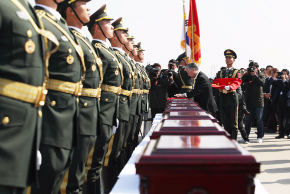 3일 오전 인천 중구 인천국제공항에서 열린 제6차 중국군 유해 인도식에서 추궈홍 주한중국대사가 유해가 담긴 봉안함을 오성홍기로 덮고 있다. 2019. 4. 3. 공항사진기자단