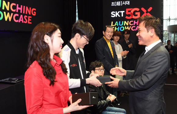 박정호 SK텔레콤 사장이 3일 서울 중구 을지로 SKT타워 로비에서 열린 ‘5GX 서비스 론칭쇼’에서 프로게이며 이상혁(페이커) 선수에게 갤럭시 신제품을 전달하고 있다. 2019. 4. 3. 박지환 기자 popocar@seoul.co.kr