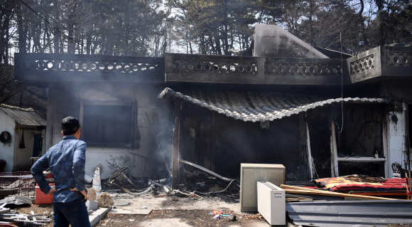 고성에서 시작된 산불이  고성.속초 인근으로 번진 5일 강원도 토성면의 한 주택이 전소된 가운데 주민이 이를 안타깝게 쳐다보고 있다.  2019. 4. 5  정연호 기자 tpgod@seoul.co.kr