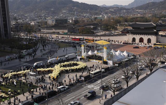 14일 오후 4시 16분에 서울 광화문광장에서 세월호 참사 5주기 ‘잊지 않을게’ 대학생 대회에서 참가자들이 노란 우산으로 세월호 리본을 만드는 퍼포먼스를 하고 있다. 2019.4.13. 뉴스1