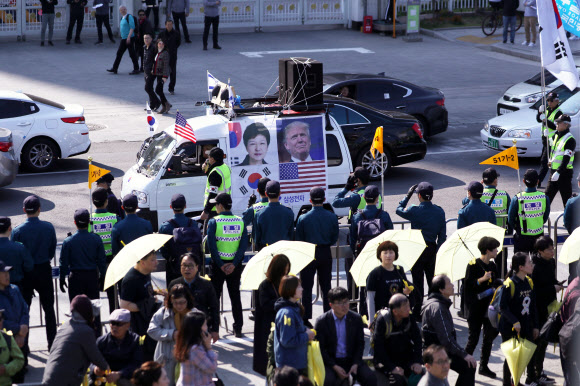 세월호 참사 5주기를 사흘 앞둔 13일 오후 서울 종로구 광화문 광장에서 추모행사가 펼쳐지는 가운데 태극기 집회를 마친 보수단체 참가자들이 행사장 주변을 행진하고 있다. 2019.4.13  연합뉴스