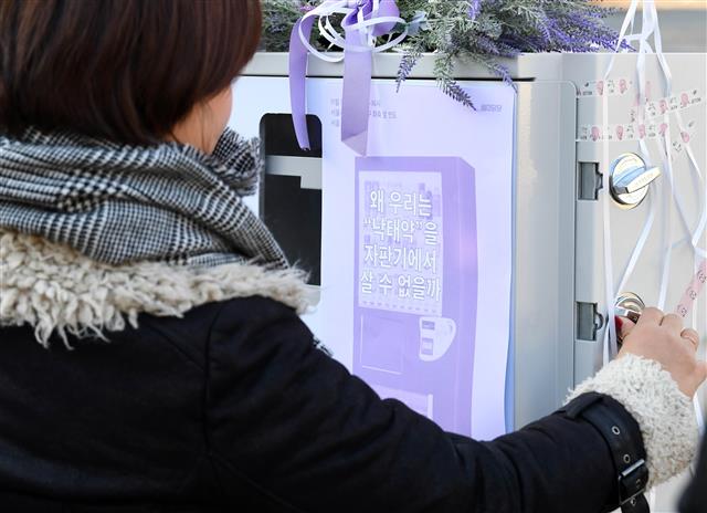 여성단체 ‘페미당당’의 한 회원이 현행법상 불법인 ‘미프진’(유산유도제) 자판기를 설치하는 퍼포먼스를 하고 있다.  서울신문 DB