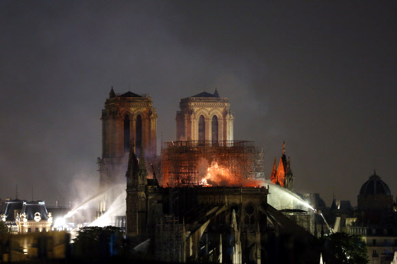 프랑스 파리의 상징으로 최대 관광명소의 하나인 노트르담 대성당이 15일(현지시간) 발생한 화재로 불길과 연기에 휩싸여 있다. 파리 AP 연합뉴스