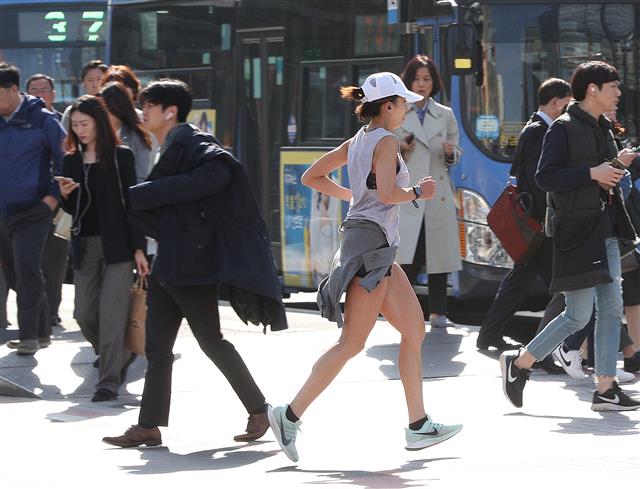 16일 오전 서울 광화문네거리에서 가벼온 옷차림을 한 시민이 운동을 하고 있다. 기상청은 이날 한낮 최고 기온이 대부분 20도를 웃돌면서 봄기운이 가득할 것으로 예보했다. 2019.4.16 뉴스1