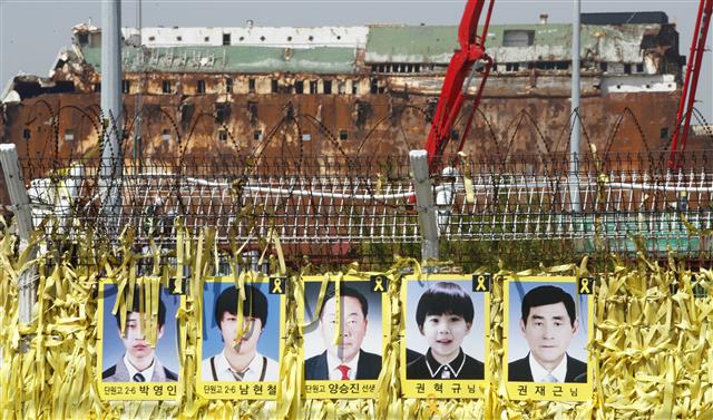 세월호 참사 5주기인 16일 전남 목포신항에서 미수습자 5인의 사진 너머로 세월호가 보이고 있다. 지난 2014년 4월 16일 제주도로 수학여행을 가던 경기 안산 단원고 학생 등 476명을 태운 세월호는 진도 앞바다에서 침몰했고, 304명(미수습자 5명 포함)의 안타까운 목숨이 희생됐다. 2019.4.16 뉴스1