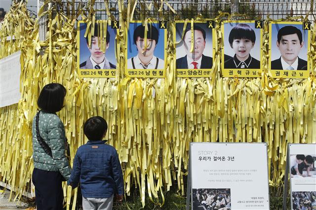 세월호 참사 5주기인 16일 전남 목포신항을 찾은 시민들이 미수습자 사진을 바라보고 있다. 지난 2014년 4월 16일 제주도로 수학여행을 가던 경기 안산 단원고 학생 등 476명을 태운 세월호는 진도 앞바다에서 침몰했고, 304명(미수습자 5명 포함)의 안타까운 목숨이 희생됐다. 2019.4.16 뉴스1
