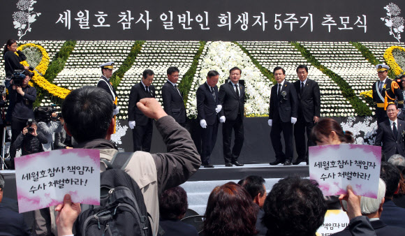 자유한국당 황교안 대표와 당 관계자들이 16일 오전 인천시 부평구 인천가족공원 내 세월호 일반인 희생자 추모관 앞에서 열린 5주기 추모식에서 헌화 및 분향 마치고 무대에서 내려오자 인천시민사회단체 회원들이 항의 구호를 외치고 있다. 2019.4.16  연합뉴스