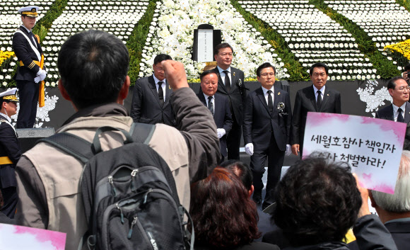 자유한국당 황교안 대표와 당 관계자들이 16일 오전 인천시 부평구 인천가족공원 내 세월호 일반인 희생자 추모관 앞에서 열린 5주기 추모식에서 헌화 및 분향 마치고 무대에서 내려오자 인천시민사회단체 회원들이 항의 구호를 외치고 있다. 2019.4.16  연합뉴스