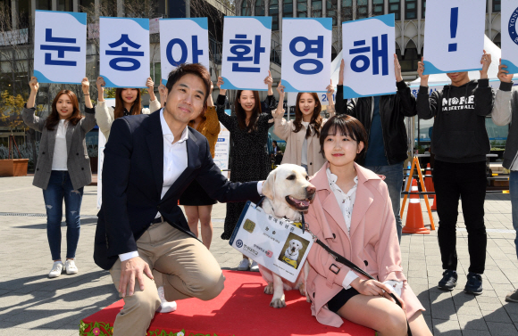 세계안내견의 날을 일주일 앞둔 17일 오전 서울 서대문구 연세대학교에서 심리학과 4학견에 재학중인 이예원 학생의 안내견에게 명예학생증을 목에 걸어준 뒤 포즈를 취하고 있다. 왼쪽은 연세대학교 언론영상학부 조창환 교수. 2019.4.17.  도준석 기자 pado@seoul.co.kr