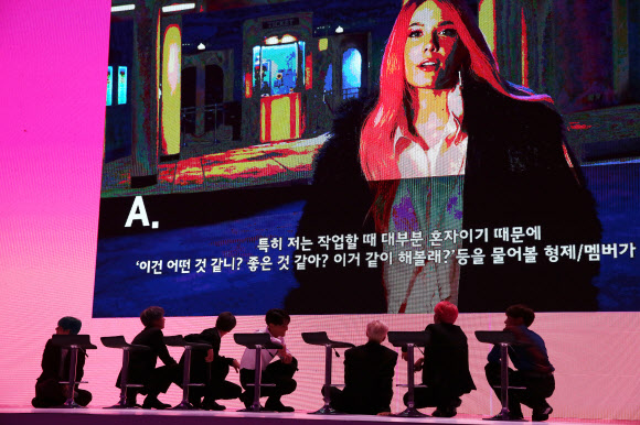 기자간담회 도중 가수 할시의 인터뷰 영상이 나오자 BTS가 취재진을 위해 바닥에 내려앉아 영상을 보고 있다.<br>연합뉴스