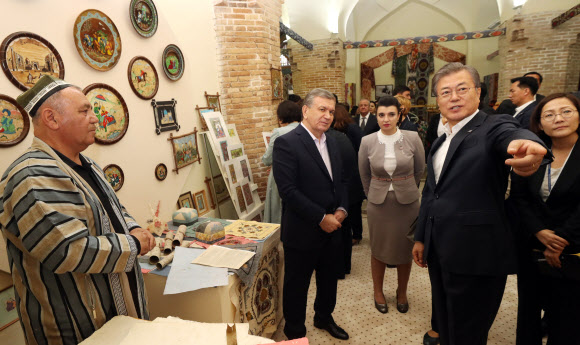 우즈베키스탄을 국빈방문 중인 문재인 대통령이 샤프카트 미르지요예프 대통령과 20일 오후 (현지시간) 사마르칸트 레기스탄 광장에서 전통 종이 상점을 살펴보고 있다. 2019.4.21  연합뉴스