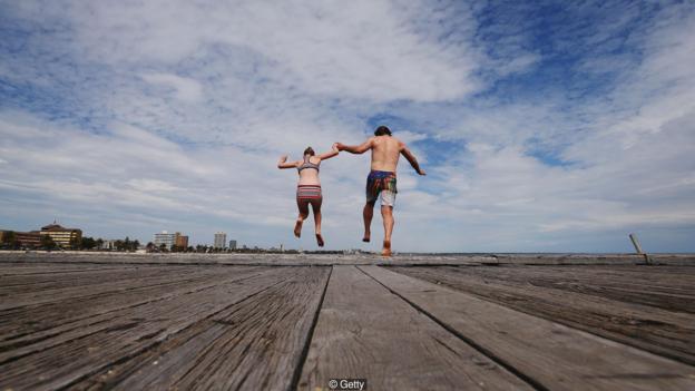호주 사우스 멜버른 비치 부둣가에서 바닷물로 뛰어드는 부녀. AFP 자료사진