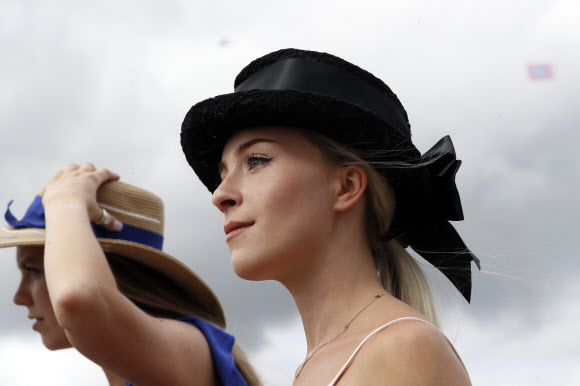 3일(현지시간) 미국 켄터키주 루이빌에서 열린 제145회 켄터키 오크스 경마 대회에서 팬들이 화려한 모자 패션을 선보이고 있다. AP 연합뉴스