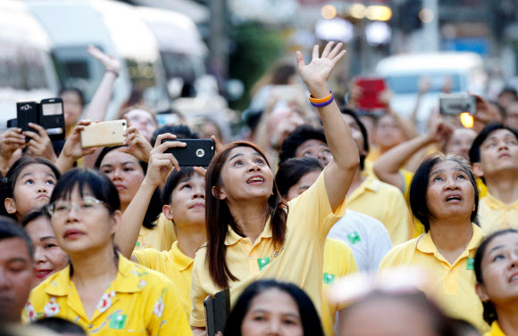 태국의 신임 국왕 마하 와찌랄롱꼰이 5일 가마를 타고 지나가자 왕실 색상이 노란색 티를 입은 시민들이 손을 흔들며 환영하고 있다.로이터 연합뉴스