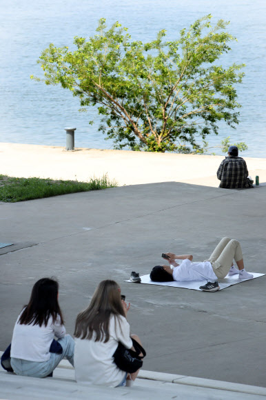 서울 낮 최고기온이 28도까지 오르며 초여름 날씨를 보인 11일 오후 서울 여의도 한강공원을 찾은 시민들이 그늘에서 더위를 식히고 있다. 2019.5.11  연합뉴스