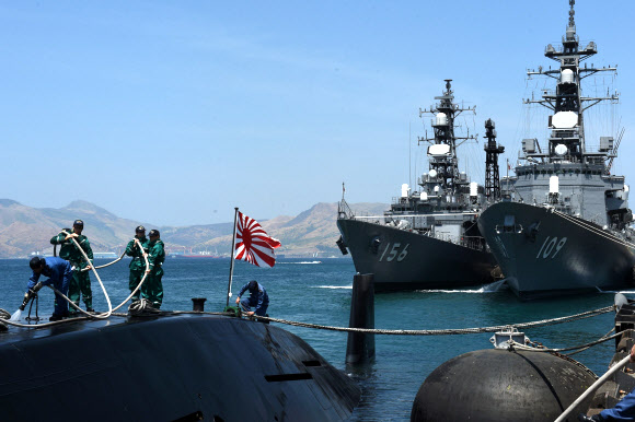 영유권 분쟁 지역인 남중국해와 가까운 필리핀 수빅항에 일본 해상자위대 잠수함 오야시오가 입항한 가운데 대원들이 잠수함 갑판 위에서 작업하고 있다. 뒤로는 오야시오 를 호위하고 온 구축함 세토기리(왼쪽)와 아리아케가 정박해 있다. 자위대 잠수함이 필리핀에 입항한 것은 2001년 이후 15년 만이다. 필리핀은 중국의 남중국해 군사기지화를 견제하기 위 해미국,일본과군사협력을강화하고있다. 2016.4 AFP 연합뉴스