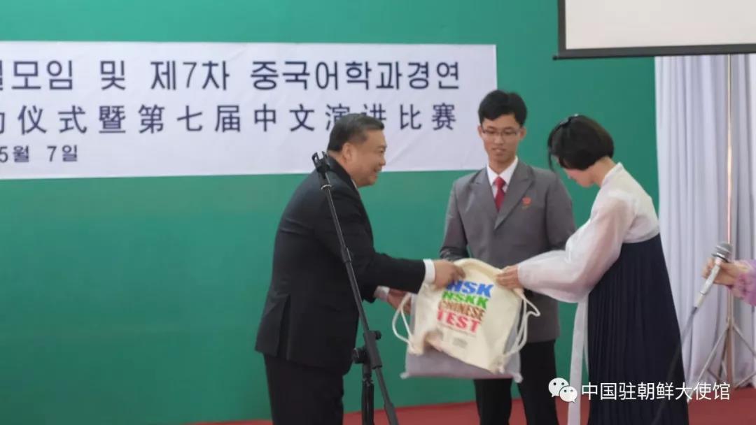 리진쥔(왼쪽) 주북한 중국 대사가 북한 학생에게 중국어능력시험(HSK) 교재를 전달하고 있다.