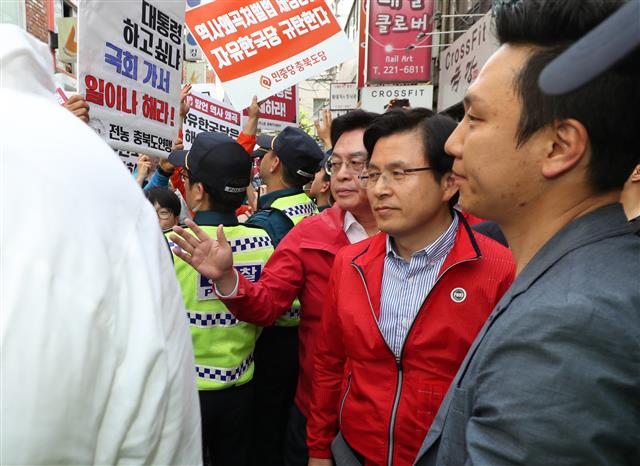 황교안 자유한국당 대표가 14일 오후 충북 청주시 상당구의 한 카페에서 청주시학교운영위원협의회와 간담회를 마친 뒤 자리를 떠나고 있다. 이날 자리에는 민주노총 충북본부 소속 회원들이 기습 시위를 벌였다. 2019.5.14 뉴스1