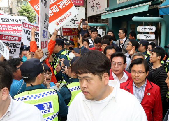 자유한국당 황교안 대표가 14일 오후 충북 청주시 상당구 한 커피점에서 학부모 간담회를 마치고 나가던 중 민주노총 충북지역본부 조합원들이 자유한국당 해체를 요구하며 시위를 벌이자 경찰의 도움을 받아 빠져나가고 있다. 2019.5.14  연합뉴스