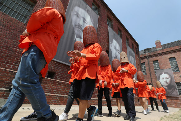 14일 오후 서울 서대문구 서대문형무소에서 열린 ‘서울 역사 올레길’ 특별교육프로그램에 참가한 언북중학교 학생들이 수감 체험을 위해 용수를 쓰고 옥사로 향하고 있다.  3·1운동 및 대한민국임시정부 수립 100주년을 맞이해 올해 3월 서울시교육청·서대문형무소역사관·대한민국역사박물관·서울역사박물관은 근·현대사 학교 교육과 연계된 특별 프로그램 운영을 위한 양해각서를 체결해 서울 역사 올레길을 이번 달까지 운영한다. 2019.5.14  연합뉴스