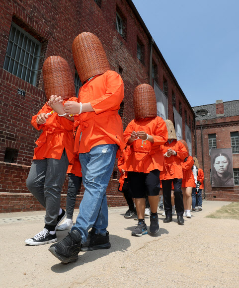 14일 오후 서울 서대문구 서대문형무소에서 열린 ‘서울 역사 올레길’ 특별교육프로그램에 참가한 언북중학교 학생들이 수감 체험을 위해 용수를 쓰고 옥사로 향하고 있다.  3·1운동 및 대한민국임시정부 수립 100주년을 맞이해 올해 3월 서울시교육청·서대문형무소역사관·대한민국역사박물관·서울역사박물관은 근·현대사 학교 교육과 연계된 특별 프로그램 운영을 위한 양해각서를 체결해 서울 역사 올레길을 이번 달까지 운영한다. 2019.5.14  연합뉴스