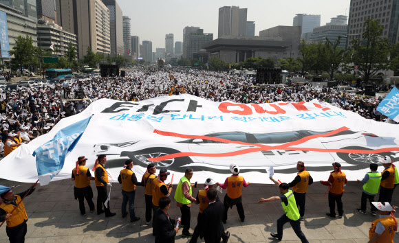서울개인택시운송사업조합 소속 택시기사들이 15일 오후 서울 종로구 광화문 광장에서 열린 ‘타다 퇴출’ 집회에서 현수막 퍼포먼스를 하고 있다. 2019.5.15  연합뉴스