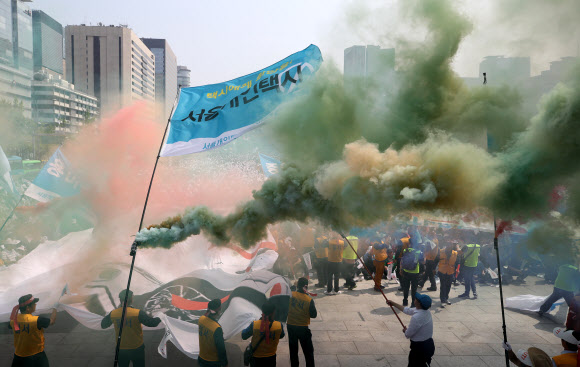 서울개인택시운송사업조합 소속 택시기사들이 15일 오후 서울 종로구 광화문 광장에서 ‘타다 퇴출’ 집회를 하며 ‘타다 OUT’이라고 적힌 대형 현수막을 찢는 퍼포먼스를 하고 있다. 2019.5.15  연합뉴스