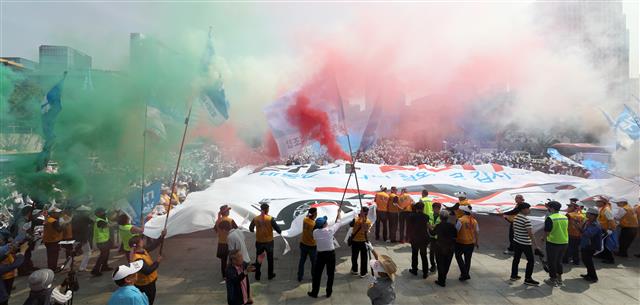 개인택시운송사업조합 소속 조합원들이 15일 오후 서울 광화문 광장에서 열린 타다(TADA) 퇴출 요구 집회에서 타다 OUT 이라고 적힌 현수막을 찢고 있다. 2019.5.15 뉴스1