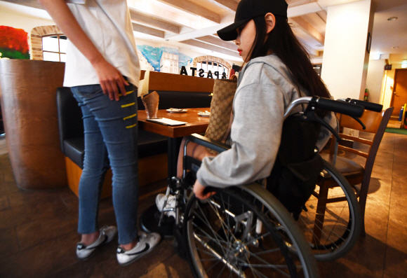 서울 혜화역 인근에서 SUNNY들이 장애인 문화시설 지도를 제작하기 위해 한 음식점을 찾아 휠체어를 타고 테이블 높이를 측정하고 있다.
