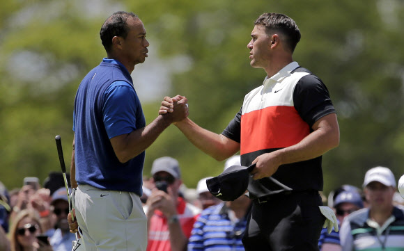 타이거 우즈(왼쪽)와 브룩스 켑칵 16일 미국 뉴욕주 파밍데일의 베스페이지 블랙코스에서 열린 PGA 챔피언십 1라운드를 동반플레이로 마친 뒤 두 손을 굳게 잡으며 서로를 격려하고 있다. [AP 연합뉴스]
