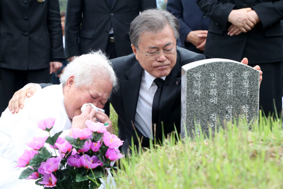 문재인 대통령이 18일 광주 국립 5·18 민주묘지 고 안종필씨의 묘역에서 어머니 이정임 씨를 위로하고 있다. 광주 연합뉴스
