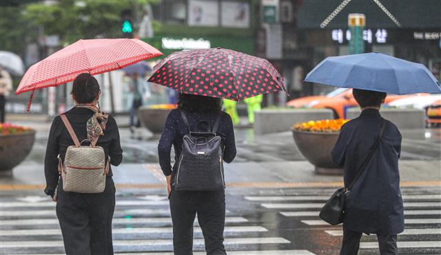 전국에 비소식이 예고된 19일 오전 서울 광화문네거리에서 시민들이 우산을 들고 발걸음을 재촉하고 있다. 2019.5.19 뉴스1
