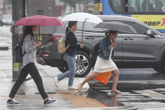 전국에 비소식이 예고된 19일 오전 서울 광화문네거리에서 시민들이 우산을 들고 발걸음을 재촉하고 있다. 2019.5.19 뉴스1