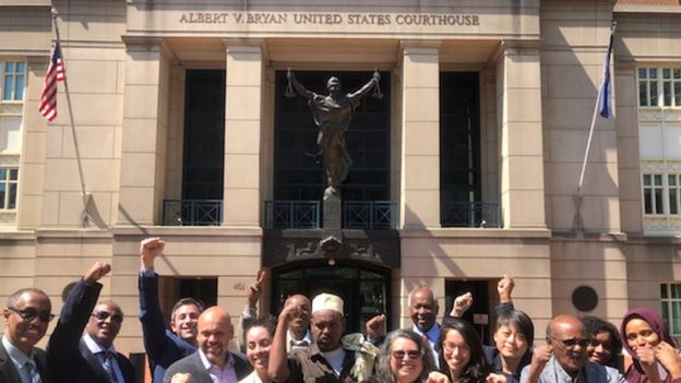파르한 타니 와르파(가운데 모자 쓴 이)가 21일(현지시간) 미국 버지니아주 알렉산드리아법원 앞에서 유죄 평결 결과에 환호하며 변호인단과 함께 팔을 들어 보이고 있다. BBC 홈페이지 캡처
