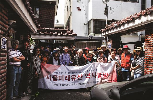 1965년 최초의 필화소설 ‘분지’의 작가 남정현 가옥 앞에서 서울미래유산 투어 참가자들이 87세 노작가와 함께 기념촬영하고 있다. 작가는 서울미래유산으로 지정된 집을 참가자들에게 개방했다.