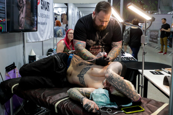 26일(현지시간) 러시아 소콜니키 전시 센터에서 열린 ‘제10회 국제 모스크바 타투 대회’에서 타투 아티스트 러스 애보트가 문신 새기는 작업을 하고 있다. 타스 연합뉴스