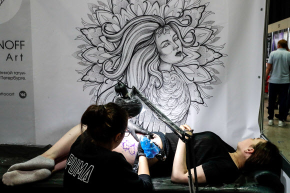 26일(현지시간) 러시아 소콜니키 전시 센터에서 열린 ‘제10회 국제 모스크바 타투 대회’에서 타투 아티스트가 문신 새기는 작업을 하고 있다. 타스 연합뉴스
