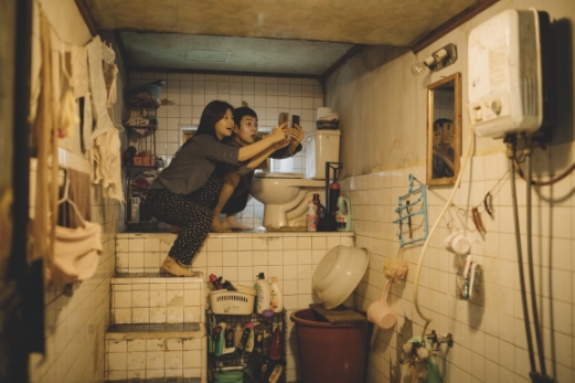 기택(송강호 분)의 가족들이 반지하주택 화장실에서 와이파이를 잡기 위해 애쓰는 영화 속 장면.