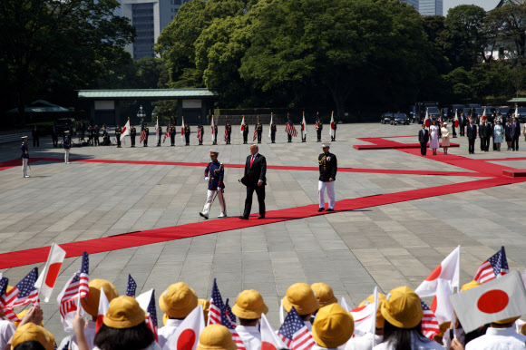 지난 27일 일본 도쿄 지요다구 왕궁에서 열린 도널드 트럼프 미국 대통령 환영행사에 동원된 인근 반초초등학교 6학년 학생들.  AP 연합뉴스