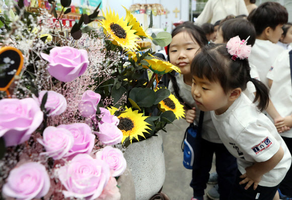 30일 대구 엑스코에서 열린 꽃박람회에서 행사장을 찾은 어린이들이 꽃 모양의 인공 조형물에서 향기가 나는지 맡아 보고 있다. 올해 10회를 맞는 ‘대구꽃박람회’는 국내 최대 규모의 실내 꽃박람회로 2일까지 열린다. 2019.5.30  연합뉴스