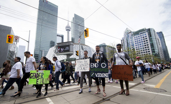 29일(현지시간) 캐나다 토론토에서 ‘2019 여성 신발 신고 1마일 걷기’ 행사가 열린 가운데 남성 참가자들이 하이힐을 신은채 걷고 있다. 신화 연합뉴스